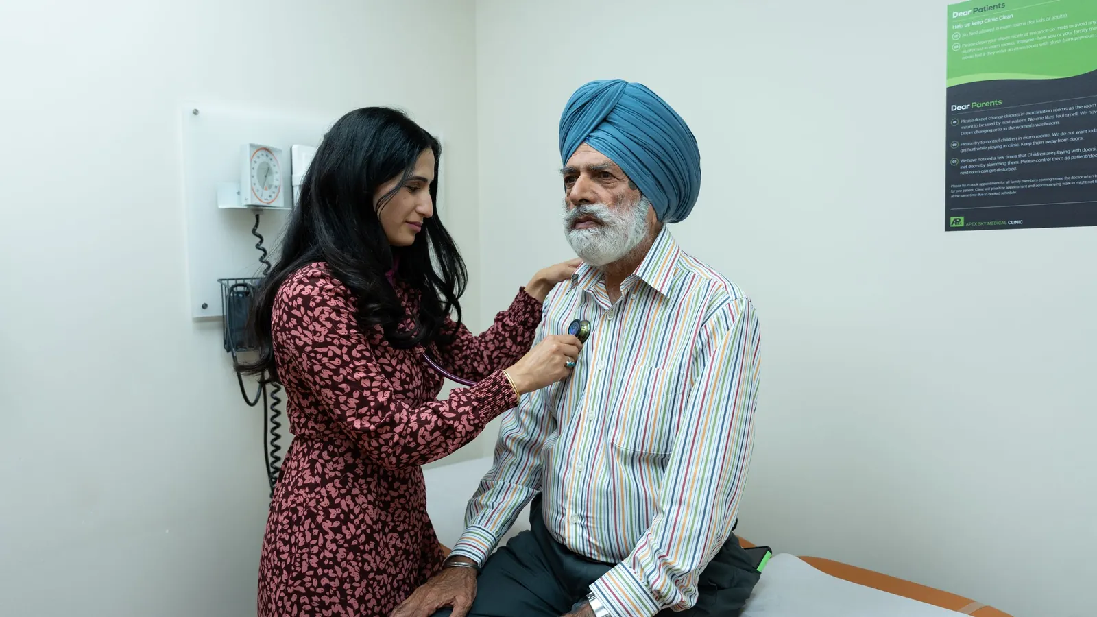 A doctor checks an elderly patient’s heartbeat with a stethoscope in a clinic